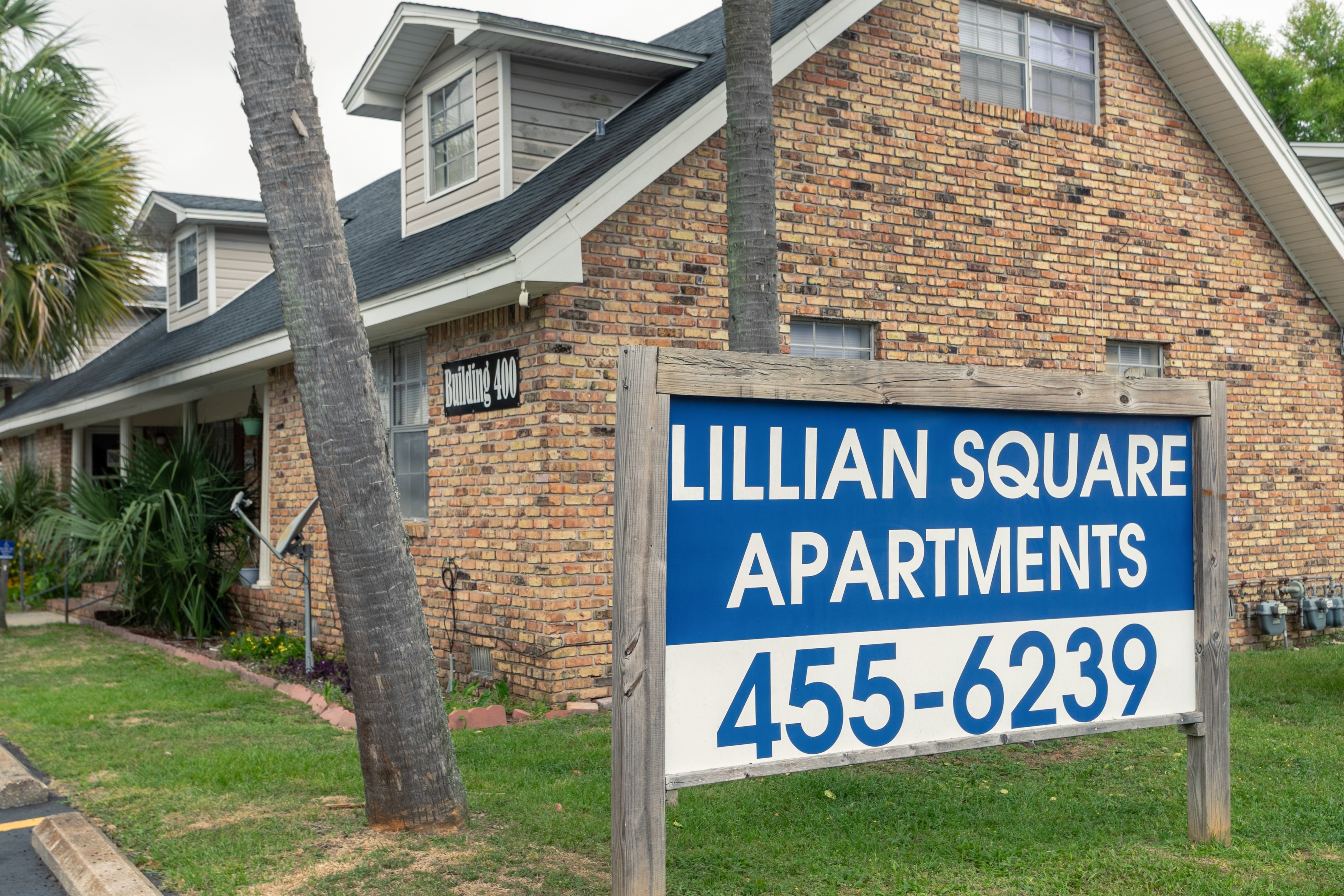 A sign for Lillian Square Apartments with a phone number on it.